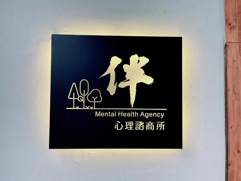 伴心理諮商所門口的發光招牌，寫著「伴 Mental Health Agency 心理諮商所」
