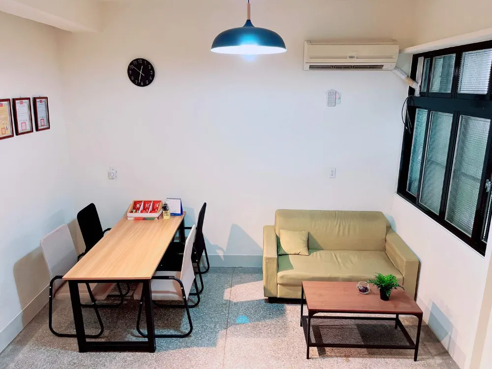 諮商所接待區全景，長桌、沙發與吊燈
